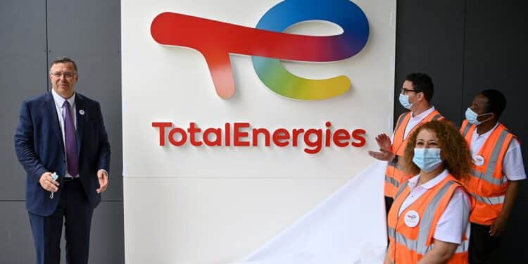 Total Chief Executive Officer Patrick Pouyanne (L) and Total employees remove a cover to reveal the new TotalEnergies logo during its unveiling ceremony, at La Defense on the outskirts of Paris on May 28, 2021. - Total shareholders voted on the strategy of the oil and gas giant, which renamed itself TotalEnergies to mark its diversification, while some investors are urging it to act more quickly. (Photo by Christophe ARCHAMBAULT / AFP)